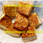 pan fried tofu in a white plate with blue and pink flowers