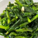 close up of pea shoots stir fried with garlic and ginger