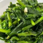close up of pea shoots stir fried with garlic and ginger