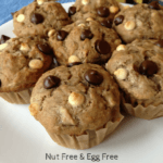 banana chocolate and white chocolate chips muffins on a white plate with bananas in the background