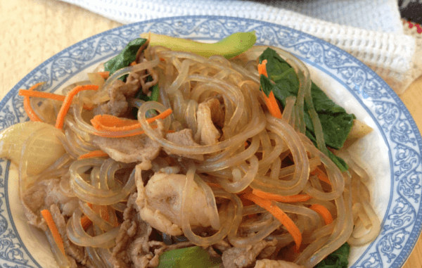 small blue and white plate containing delicious beef japchae