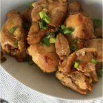 instant pot chicken thighs on a white platter, garnished with green onions