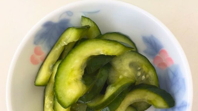 sweet pickled cucumbers served in a small round dish