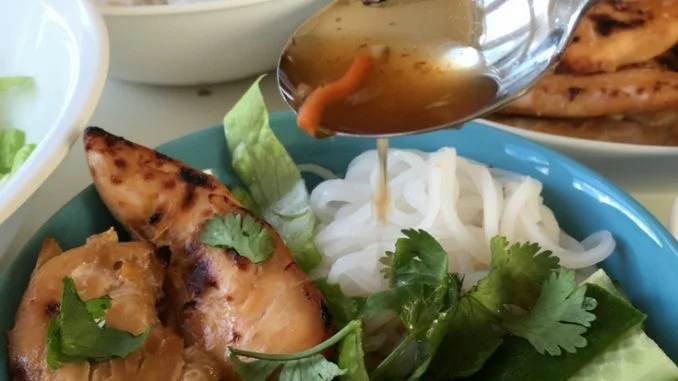 Spoon on some nuoc cham onto vietnamese chicken and rice vermicelli noodles