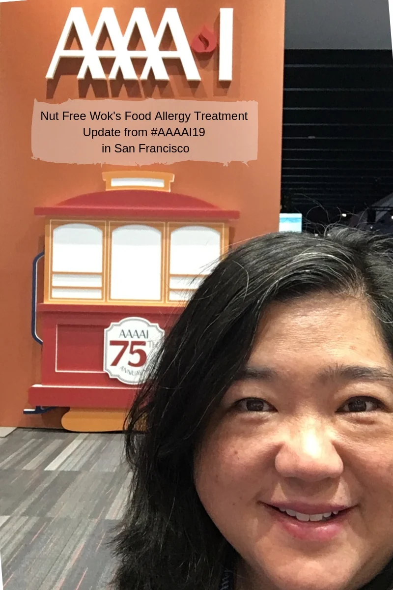 Sharon Wong from Nut Free Wok standing in front of #AAAAI19 sign with a cable car