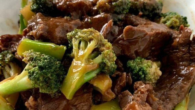 Broccoli Beef is ready to eat, photographed in a white serving bowl.