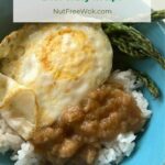 Dairy-free beef gravy over rice, served with an over easy egg and roasted asparagus in a blue bowl