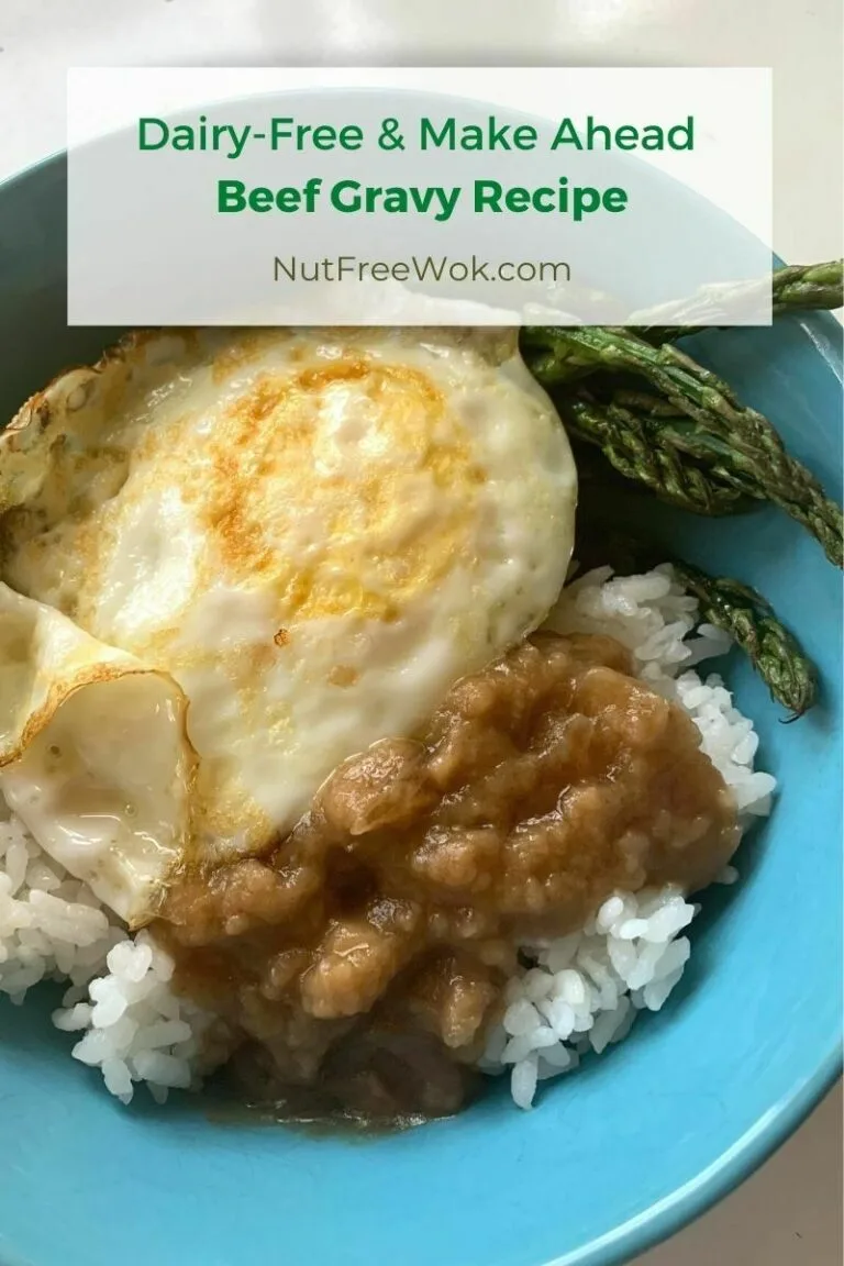 Dairy-free beef gravy over rice, served with an over easy egg and roasted asparagus in a blue bowl