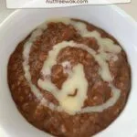 bowl of champorado, chocolate rice porridge, in a bowl with a swirl of sweetened condensed milk