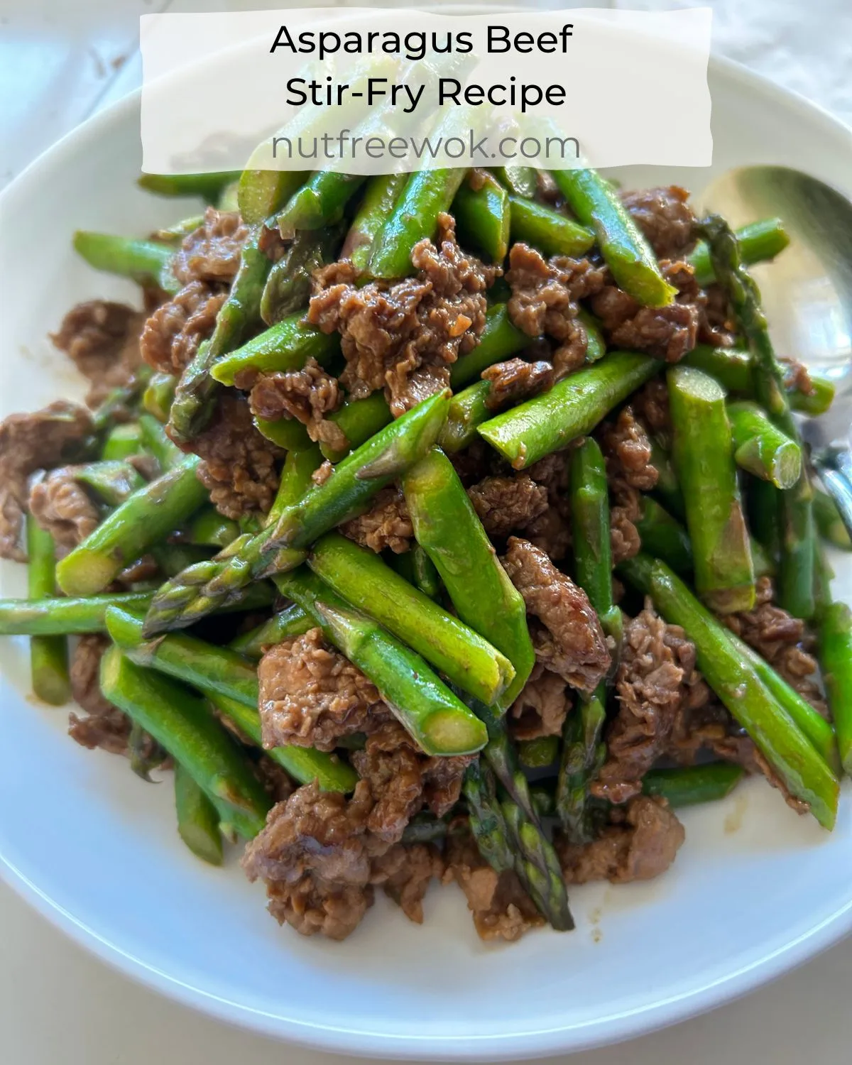 Asparagus stir fried with beef in a white serving plate.