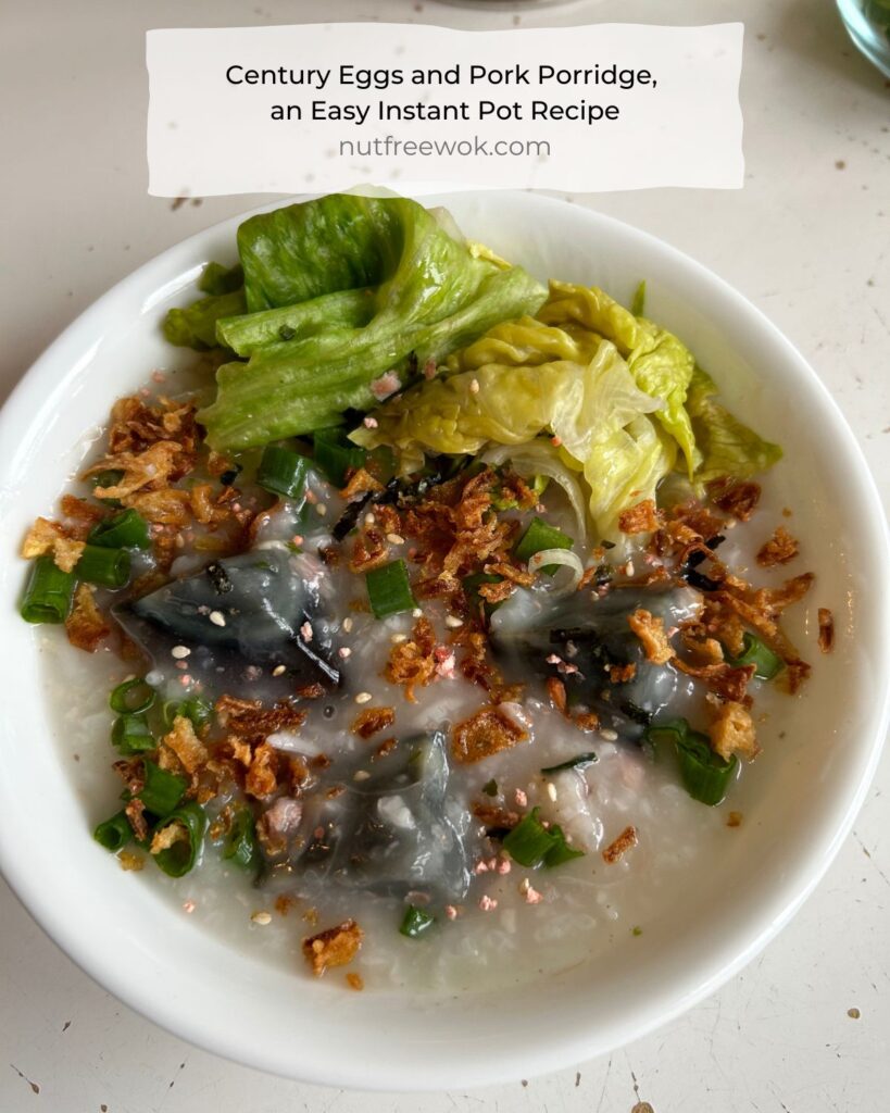 close up of century eggs and pork porridge topped with optional sauteed iceberg lettuce, fried onions, chopped scallions, and furikake. 