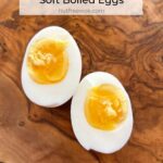 close up of a soft boiled egg cut in half on a wooden cutting board