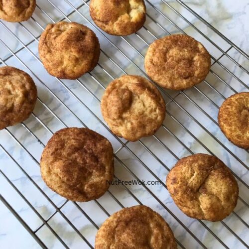 snickerdoodles resting on a cooling sheet