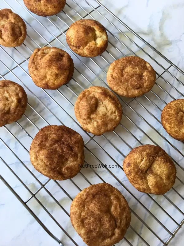 snickerdoodles resting on a cooling sheet