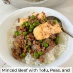Minced Beef with Tofu, Peas, and Oyster Sauce over rice in a white bowl with a spoon.