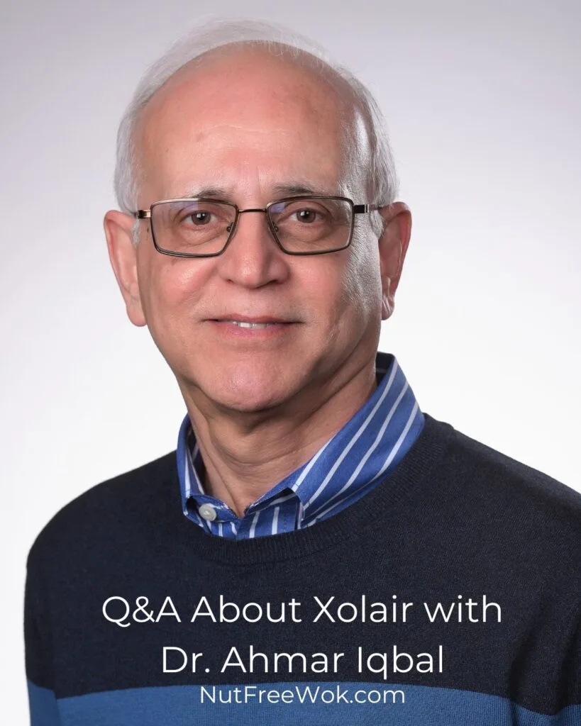 headshot of Dr. Ahmar Iqbal, white background wearing a blue shirt and blue sweater