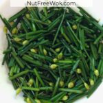 stir fried garlic chives in a white plate