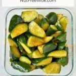 overhead view of cucumber salad dressed with soy sauce and sesame oil in a glass storage container