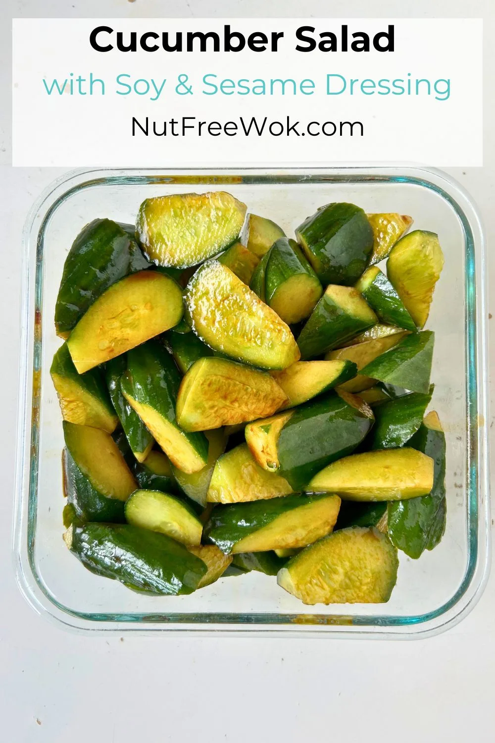 overhead view of cucumber salad dressed with soy sauce and sesame oil in a glass storage container