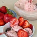 strawberry ice cream garnished with sliced strawberries in a bowl