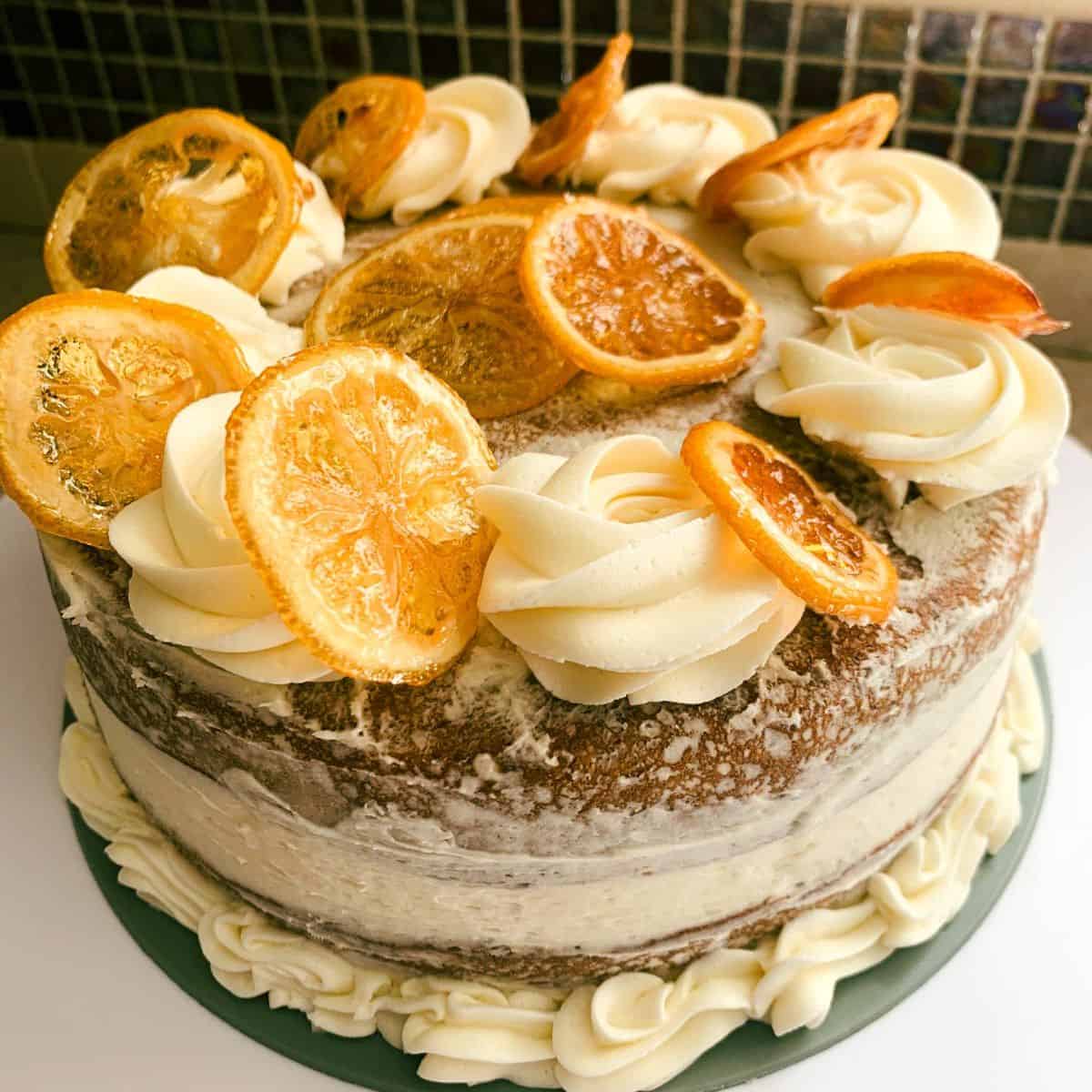 gluten free lemon cake decorated with frosting and candied lemon slices