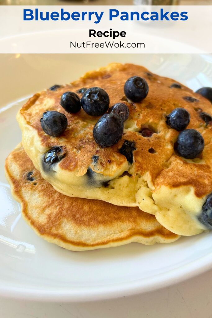 2 blueberry pancakes topped with fresh blueberries