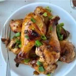 soy garlic chicken drumsticks served in a white serving bowl, with a fork on the side