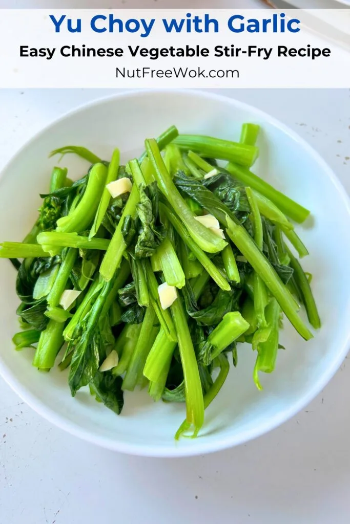 yu choy stir fried with garlic served in a round white serving bowl