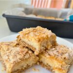 creamy lemon crumble bars arranged on a plate