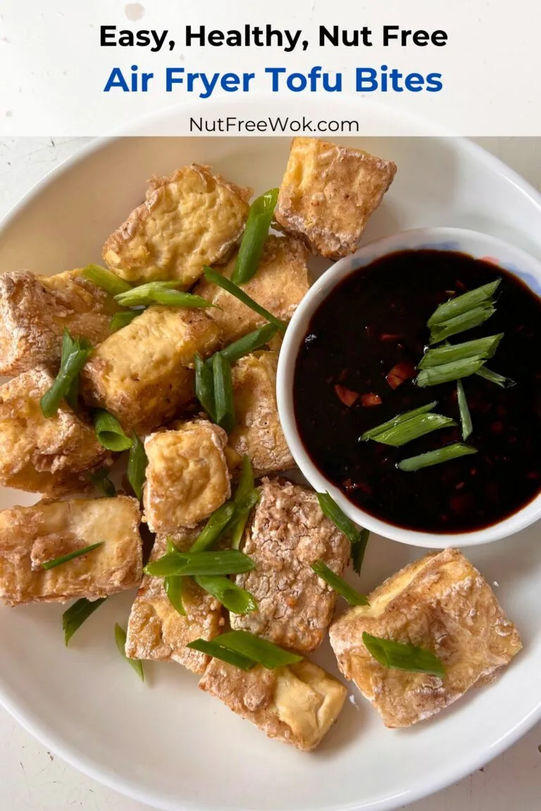 golden brown and crispy air fryer tofu bites served on a round white plate with a dip on the side