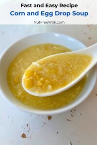 corn and egg drop soup in a porcelain soup spoon and white bowl