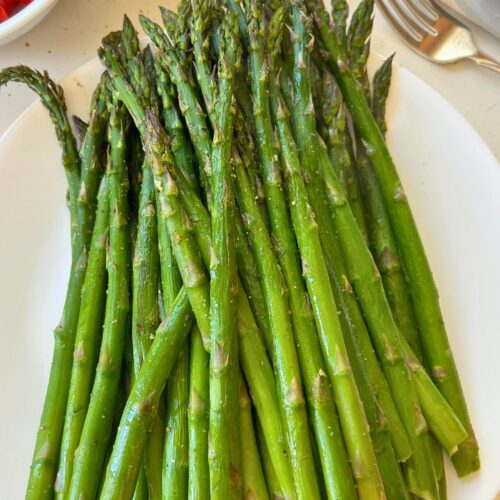 Oven roasted asparagus on a white plate