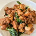 pan fried Taiwanese popcorn chicken with basil served in a paper towel lined white plate