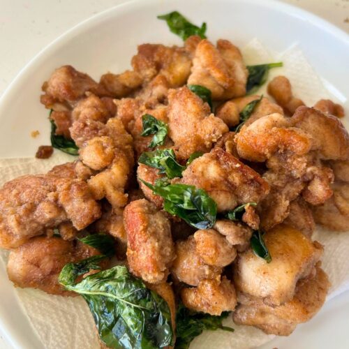 pan fried Taiwanese popcorn chicken with basil served in a paper towel lined white plate