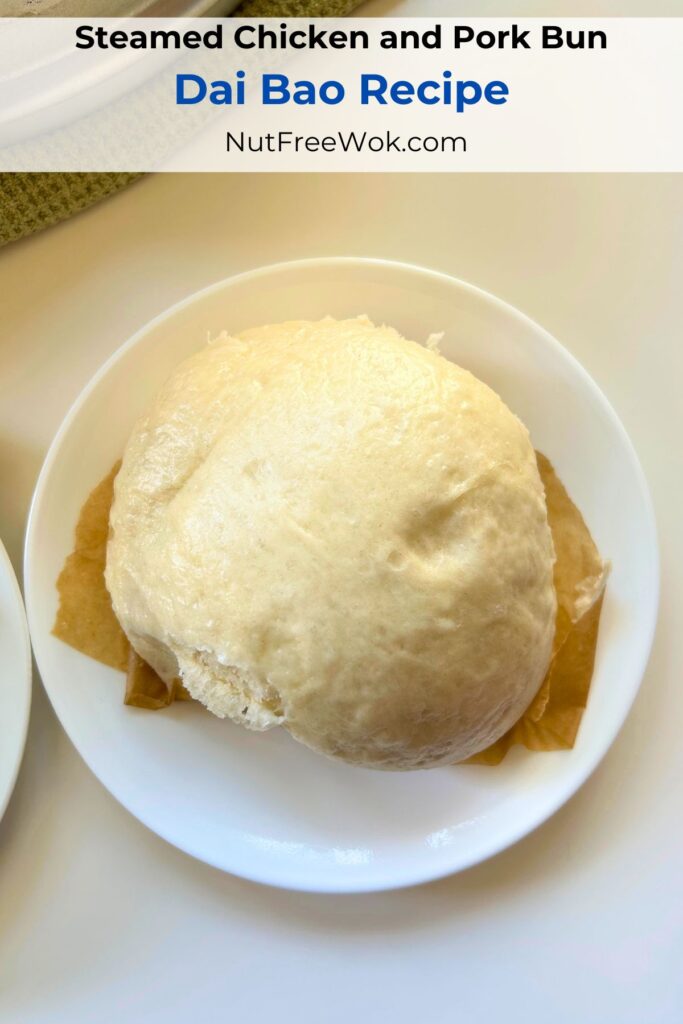 One steamed dai bao on a 6 inch cake plate to illustrate that these steamed chicken and pork buns are large.